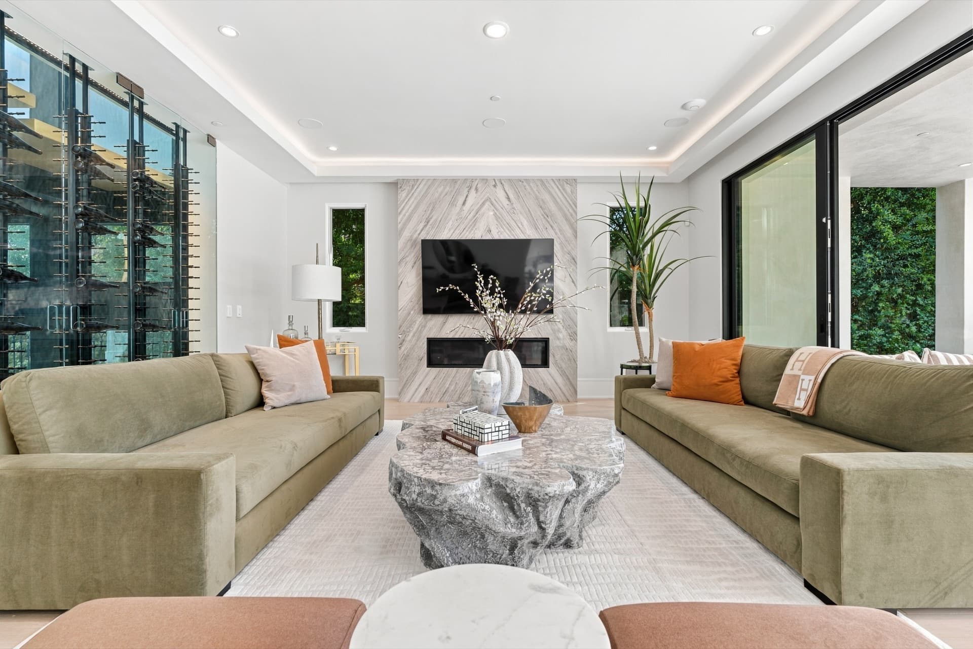 Living room with two sofas, a marble fireplace wall and open blinds