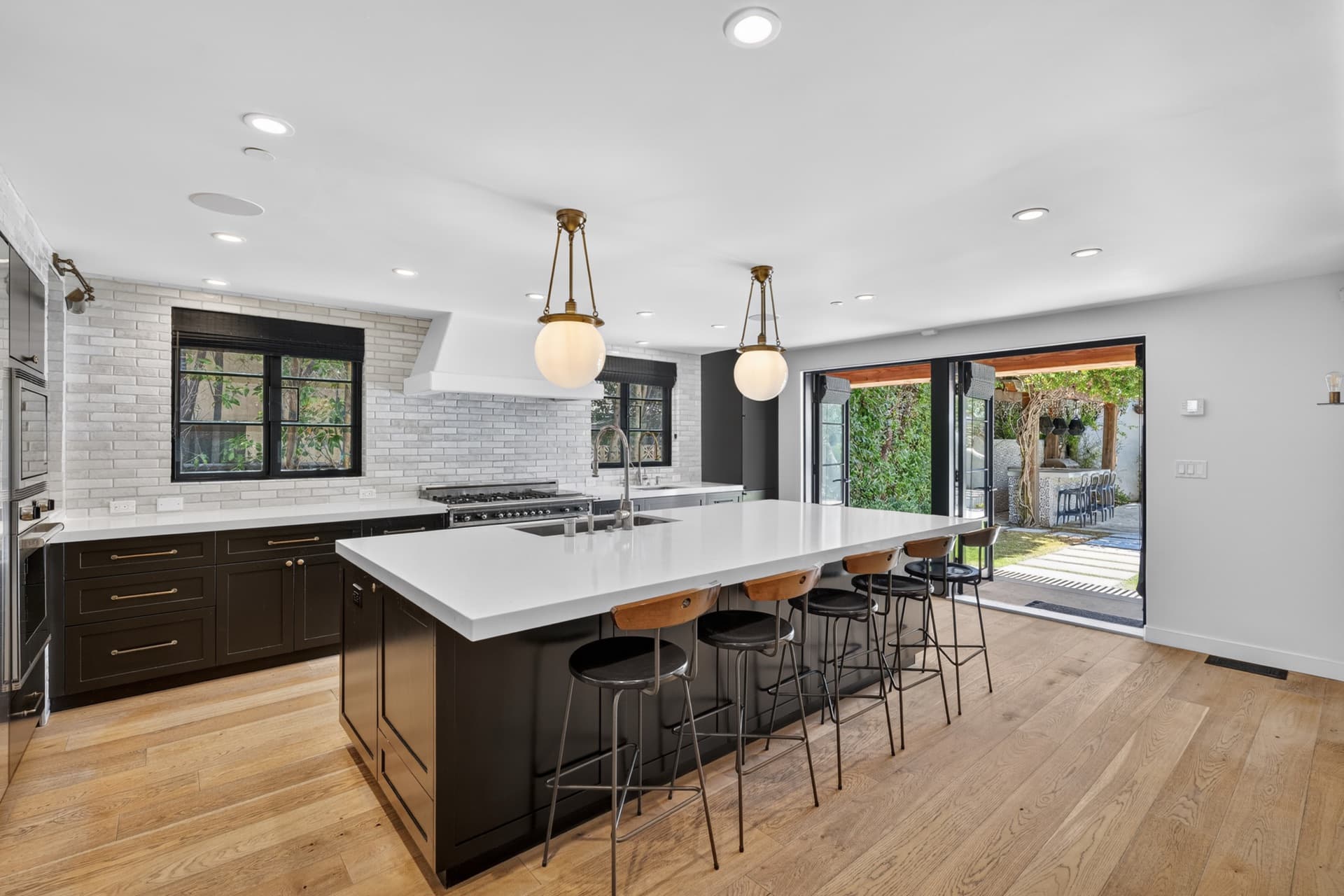 Bright kitchen with a long white island, pendant lights and clear counters