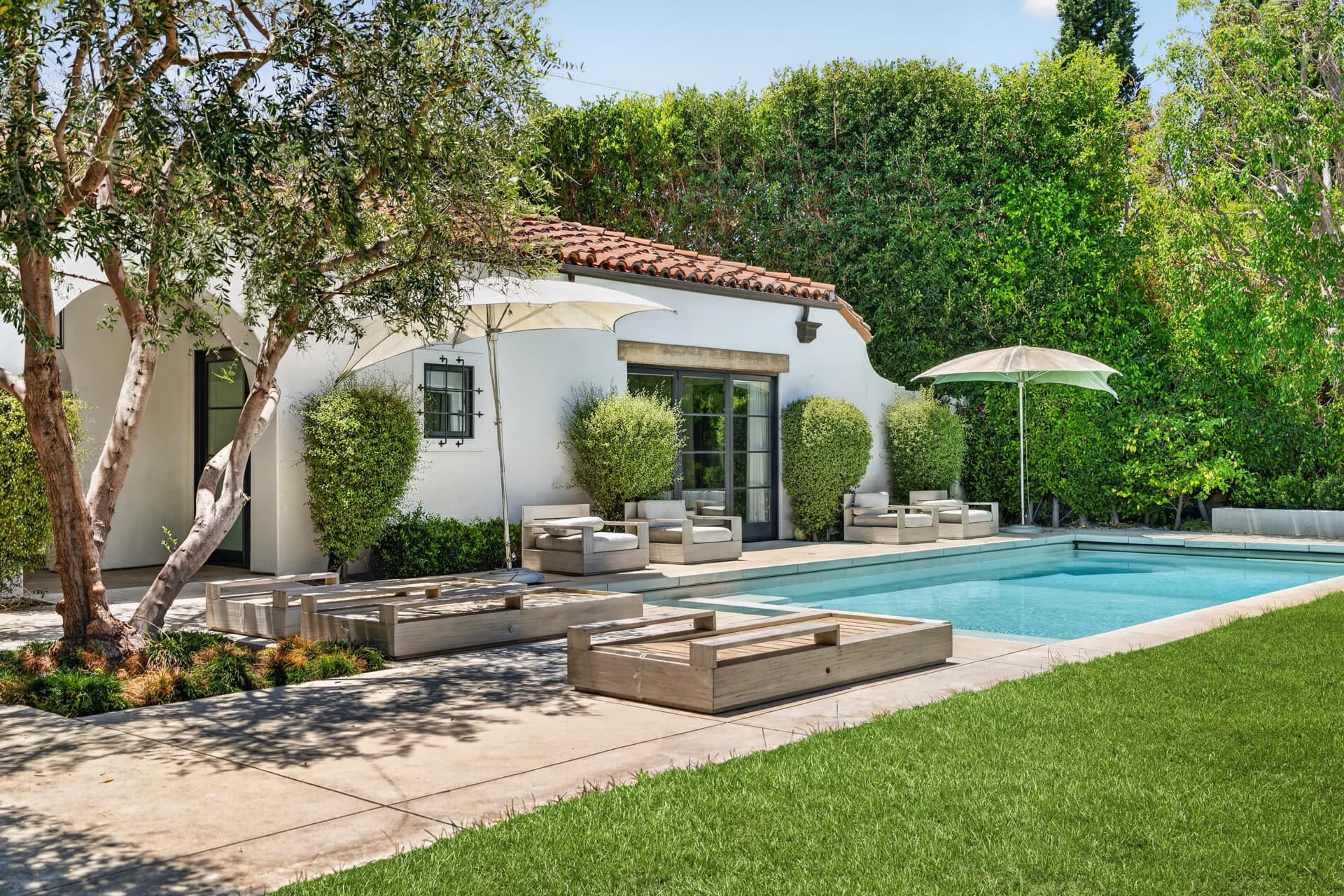 Spanish-style home with a pool and olive trees