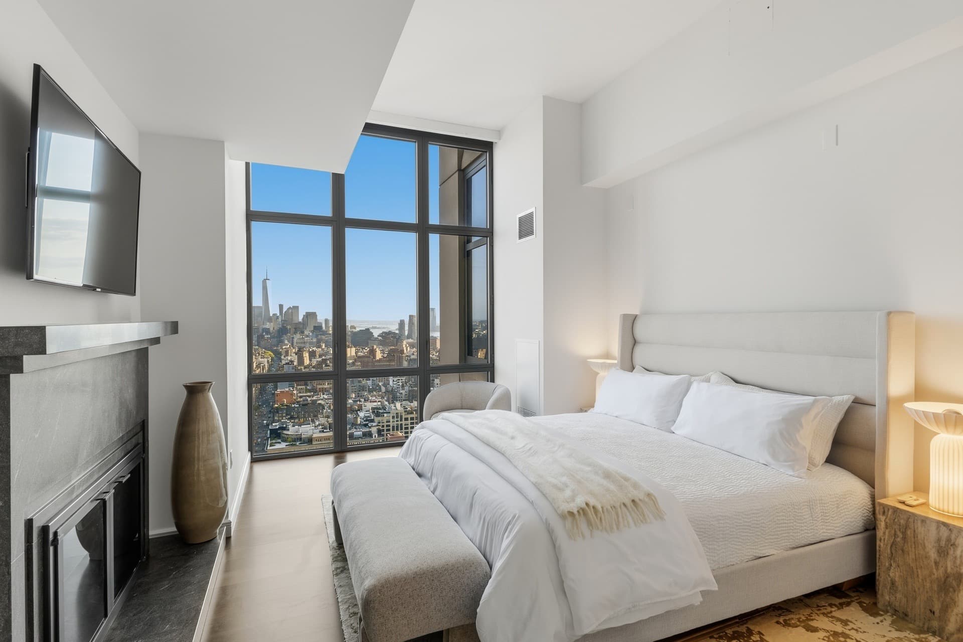 Primary bedroom with a fireplace and a city view