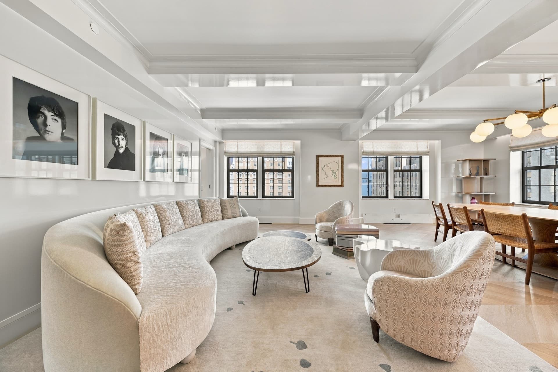 Bright open living and dining room with a curved sofa and tall windows