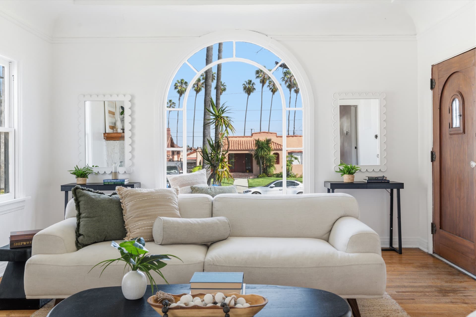 Living room with an arched window and palm trees